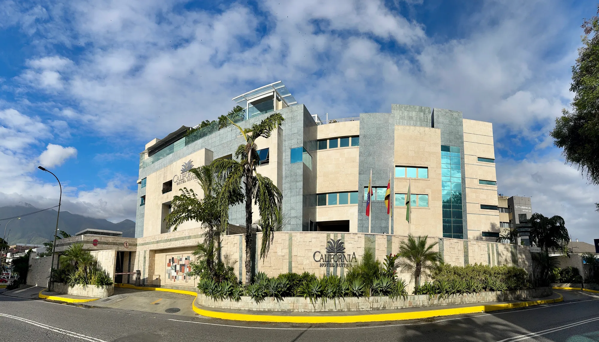 Fachada del California Hotel & Suites en La California Sur, Caracas, con el Ávila de fondo